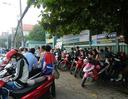 Phụ huynh chờ con trước điểm thi của trường ĐH Tài chính Maketting trên đường Phan Đăng Lưu (Q Phú Nhuận) - Ảnh: Dương Cầm