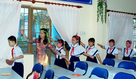 Mỗi tiết học của cô giáo Phạm Thị Thùy đều được cụ thể bằng các trò chơi, trải nghiệm thực tế. Trong ảnh: Cô Thùy tổ chức cho học trò múa cồng chiêng để tìm hiểu về văn hóa Tây Nguyên).