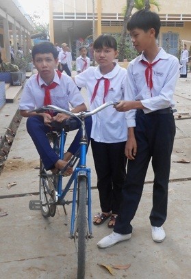 Thương em trai tật nguyền, em Cẩm (đứng giữa) xin ở lại lớp để để học chung với Lai và cõng em đến trường.