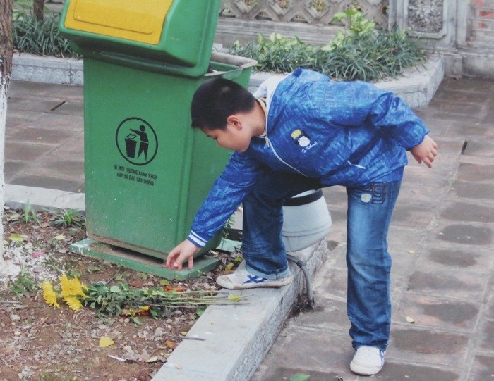 Bức ảnh "Em vứt rác vào thùng bảo vệ môi trường" của bạn Nguyễn Đình Dũng, lớp 4A Trường Tiểu học Đoàn Thị Điểm.