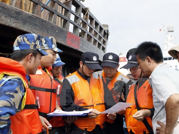 Cảnh sát biển Việt Nam và Cảnh sát biển Trung Quốc kiểm tra giấy phép đánh bắt cá của ngư dân Trung Quốc. Ảnh: TTXVN.