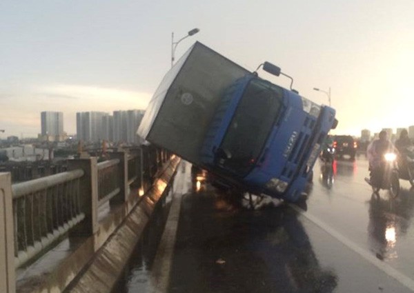 Chiếc ô tô bị gió hất đổ trên cầu Vĩnh Tuy. ảnh: otofun.