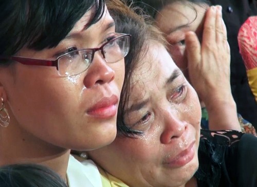 Con gái và vợ liệt sĩ Trần Văn Phương trong một buổi lễ tưởng niệm các chiến sĩ hy sinh tại đảo Gạc Ma. Ảnh: Hồng Phúc