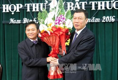 Bí thư Tỉnh ủy Nam Định Đoàn Hồng Phong (phải) tặng hoa chúc mừng ông Nguyễn Phùng Hoan. Ảnh: Văn Đạt - TTXVN