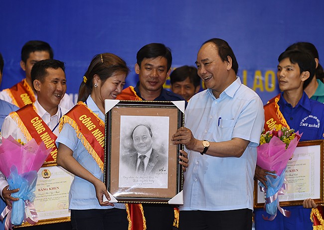 Công nhân tặng Thủ tướng Nguyễn Xuân Phúc bức ký họa chân dung Thủ tướng. ảnh: VGP.