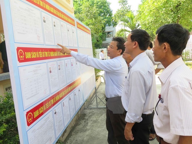 Cử tri huyện Phú Ninh, Quảng Nam tìm hiểu, lựa chọn các ứng cử viên xứng đáng trong danh sách niêm yết. (Ảnh: Đoàn Hữu Trung/TTXVN).