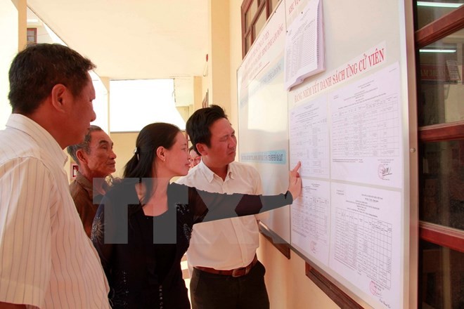 Cử tri xã Trạm Hành, Xuân Trường, thành phố Đà Lạt xem bảng niêm yết giới thiệu các ứng cử viên. (Ảnh: Đặng Tuấn/TTXVN).