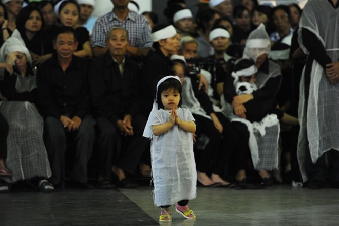 Con gái nhỏ hơn 2 tuổi của trung tá Lê Văn Đình (nhân viên tuần thám trên không) trong lễ tang. ảnh: VNE.