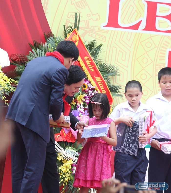 Bộ trưởng Phùng Xuân Nhạ và Chủ tịch UBND thành phố tặng quà cho các em học sinh khiếm thị. ảnh: Ngọc Quang.