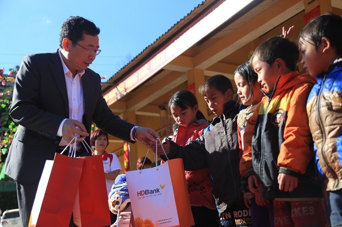 Ông Vũ Hồng Đức – Giám đốc HDBank Lào Cai tận tay áo ấm cho các bé.