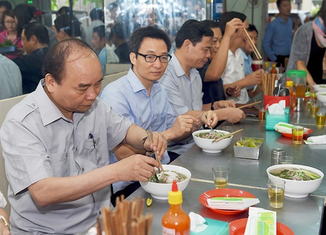 Thủ tướng Nguyễn Xuân Phúc và Phó Thủ tướng Vũ Đức Đam trong một chuyến đi tìm hiểu đời sống của nhân dân đã dừng chân tại quán ăn bình dân tại phường Tân Thành (TP.HCM). ảnh: VGP.