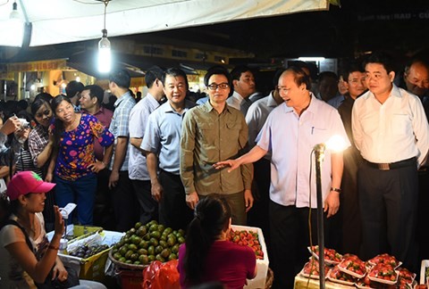 Thủ tướng Nguyễn Xuân Phúc bất ngờ xuất hiện tại chợ đầu mối Long Biên vào sáng sớm, thăm hỏi động viên bà con tiểu thương. ảnh: VGP.