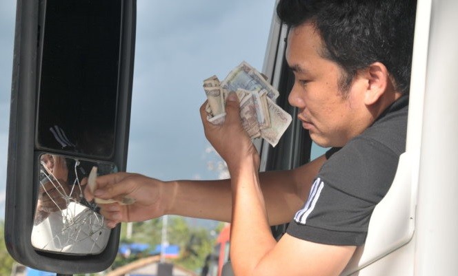 Lái xe trả tiền lẻ để phản ứng vị trí đặt trạm và mức thu phí tại Trạm Cai Lậy (Tiền Giang). ảnh: Tuổi trẻ.