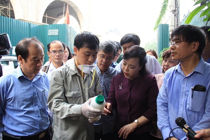 Bộ trưởng Y tế và đoàn công tác kiểm tra quy trình pha chế thuốc phun muỗi. ảnh: moh.gov.vn