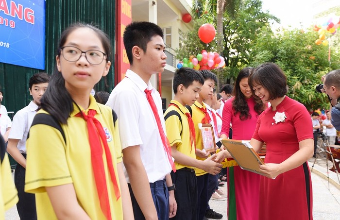 Cô giáo Hoàng Kim Uyên - Phó Hiệu trưởng Trường Trung học Cơ sở Giảng Võ trao phần thưởng, động viên học trò bước vào năm học mới. ảnh: Hải Phong.