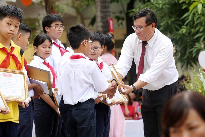 Thầy Lê Việt Trung - Phó Hiệu trưởng nhà trường tặng giấy khen cho học trò. ảnh: Hải Phong.