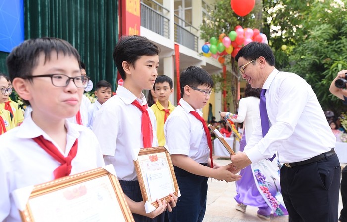 Thầy Đoàn Công Thạo - Hiệu trưởng nhà trường trao bằng khen cho những học sinh có thành tích xuất sắc. ảnh: Hải Phong.