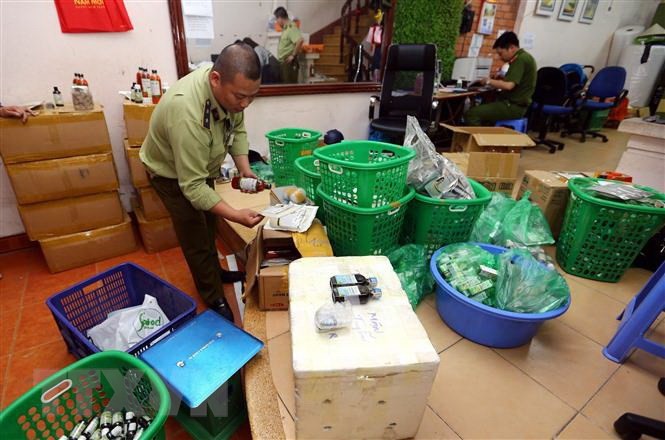 Đội quản lý thị trường số 15 kiểm tra và thu giữ lượng lớn hàng thực phẩm chức năng không rõ nguồn gốc tại số nhà 5, ngõ 125 thuộc quận Hoàng Mai (Hà Nội). (Ảnh: Danh Lam/TTXVN)