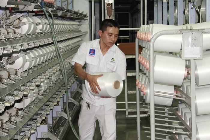 Công nhân kỹ thuật xưởng Filament - Nhà máy xơ sợi Đình Vũ đứng máy sản xuất sợi DTY.