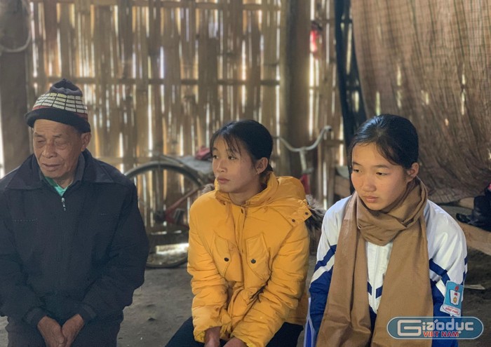 Mùng Thị Lệ (bên phải) và em gái Mùng Thị Thùy Linh bên ông nội trong ngôi nhà cũ nát của gia đình. Ảnh: C.K.A.