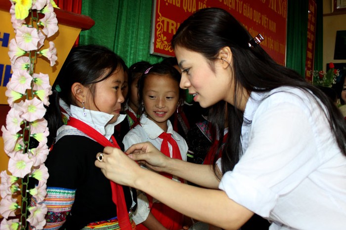 Khi phát hiện một em học sinh quàng khăn đỏ chưa đúng, Lisa Vân Anh đã hướng dẫn và tự tay quàng lại cho các em.