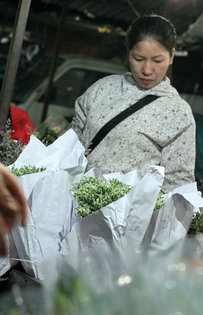 Chị Thúy, một người kinh doanh hoa tươi ở Hà Đông đang tìm cho mình những bó hoa ưng ý.