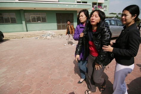 Chị Hà (giữa) hoảng hốt khi phát hiện con mình nằm dưới lan can tầng hai của tòa nhà.