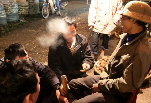 Một số người lao động tại chợ đầu mối rau quả Long Biên thì ngồi tụm lại bên nhau hút những điếu thuốc lào cho ấm bụng.