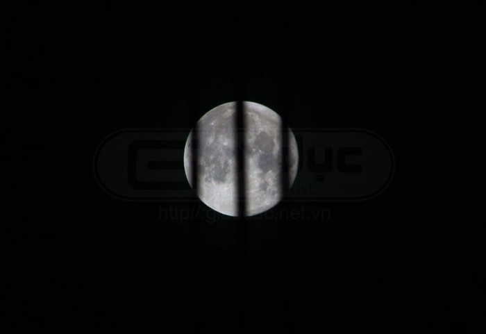 Siêu mặt trăng bị những dây điện cao thế che lấp khi nhìn từ dưới lên. Xem siêu mặt trăng đêm 5/5/2012 trên thế giới