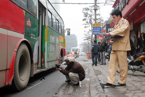 Cảnh sát khám nghiệm hiện trường vụ xe buýt số 20 của Xí nghiệp xe buýt 10.10 cán nát bàn chân một sinh viên trên phố Phạm Ngọc Thạch.