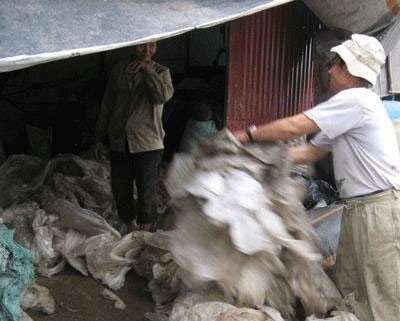 Rác tràn ngập khắp nơi trong làng được những người công nhân chuyển vào tái chế