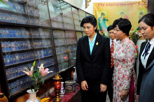 Hướng dẫn viên du lịch giới thiệu cho nữ thủ tướng tại khu vực để di ảnh của những người đã chết được thờ tại điện Tam Bảo.