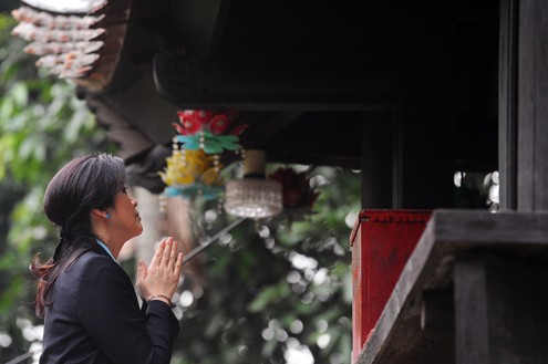 Em gái của cựu thủ tướng Thái Lan Thaksin Shinawatra kính cẩn quỳ xuống chắp tay vái trên chùa Một Cột.