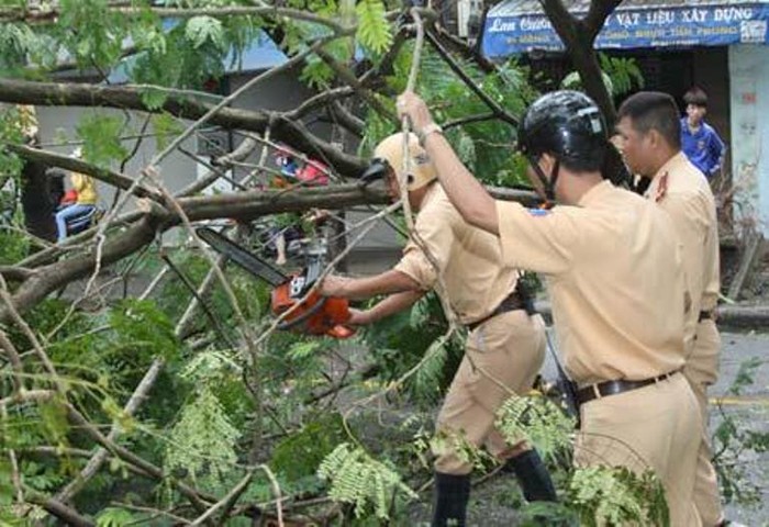Lực lượng cảnh sát giao thông ra sức khắc phục sự cố sau mưa bão.
