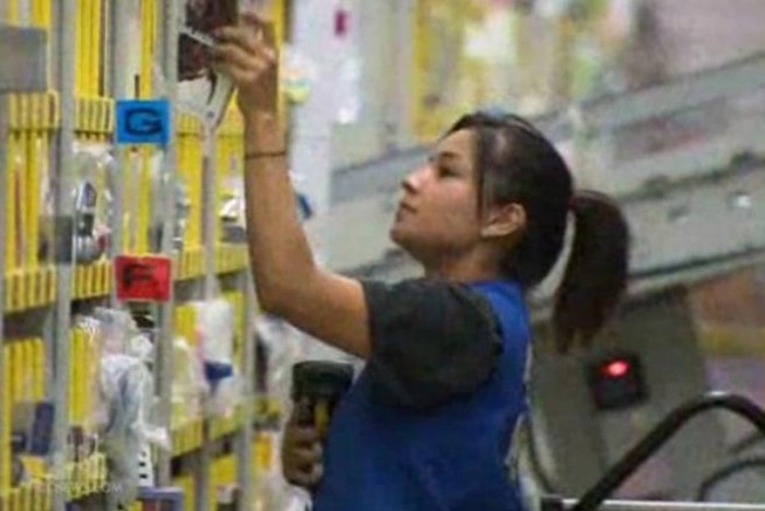 Người nữ công nhân này đang lấy đồ ra khỏi giá hàng. Cô là một trong số 70.000 nhân viên đang làm việc ở các trung tâm phân phối của Amazon tại Mỹ trong mùa mua sắm năm nay.