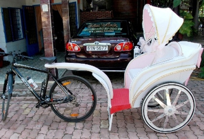 Xe rước dâu chính là chiếc xe đạp của chú rể được kéo theo một chiếc kiệu trang trí lộng lẫy. Thay vì "đóng bộ" comple cà vạt thì chú rể diện nguyên bộ đồ đua xe đạp. Thật là độc đáo và ý nghĩa.