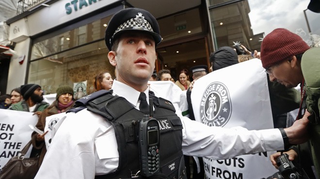 Người dân Anh biểu tình chống hành vi trốn thuế của Hãng Starbucks ở London hôm 8/12. (Ảnh: Reuters)