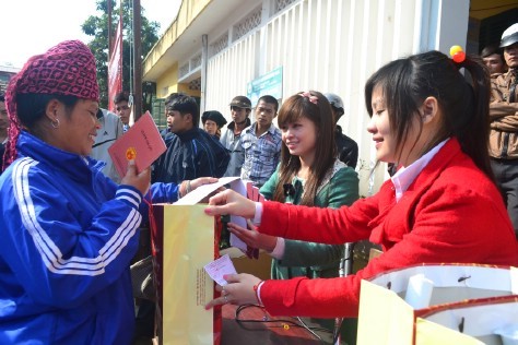 Tình nguyện viện trong đoàn trao quà cho người dân.