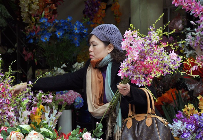 Một vị khách đang chọn những bông hoa lan nhựa