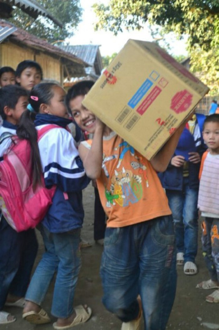 Những đứa trẻ xã Mường Mô hào hứng vác những thùng quà bánh kẹo Tết cùng đoàn từ thiện.