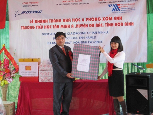 Đại diện tổ chức từ thiện trao quà cho thầy hiệu trưởng trường Tiều học Tân Minh A.