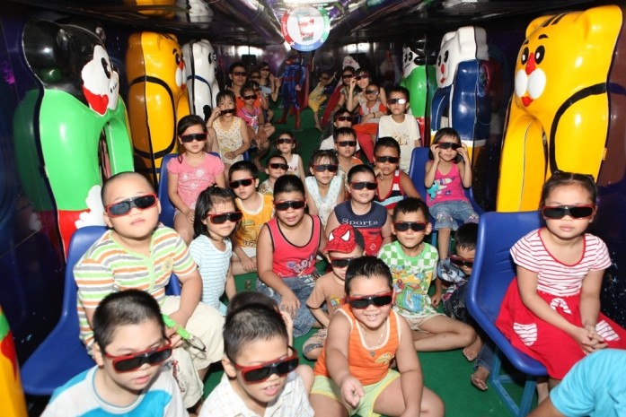 Các em nhỏ đang khám phá thế giới kỳ thú trên xe bus 3D của IZZI Ngon.