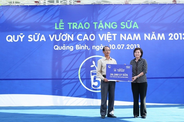 Bà Bùi Thị Hương - GĐ Đối Ngoại Vinamilk trao bảng sữa tượng trưng cho Ông Lê Quang Sỹ - GĐ Quỹ bảo trợ trẻ em Tỉnh Quảng Bình.