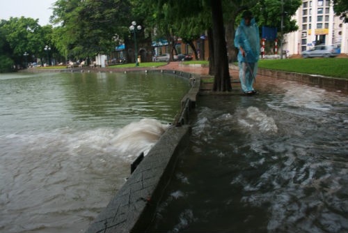 Nước trên đường chảy xối xả xuống hồ Hoàn Kiếm.