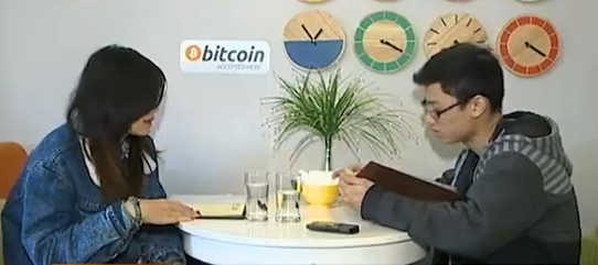 Khách hàng tỏ ra hiếu kỳ trước thông báo chấp nhận thanh toán bằng Bitcoin được dán khắn quán. (Ảnh cắt từ clip VTV)
