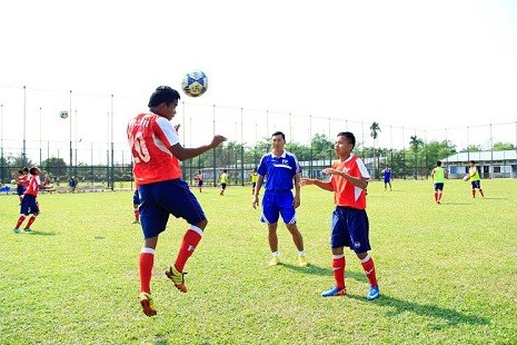 HLV Hứa Hiền Vinh đang hướng dẫn các cầu thủ kỹ năng chơi bóng bằng đầu.