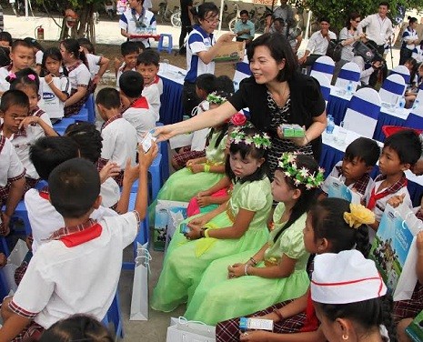 Bà Bùi Thị Hương – Giám Đốc Đối Ngoại Vinamilk trao sữa cho các em học sinh huyện Ba Tri, Bến Tre.