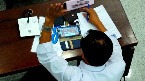 Chiều ngày 10/7 tại kỳ họp thứ 14, HĐND khóa VIII TP.HCM một vị đại biểu vẫn vô tư ngồi chơi game đánh bài trên điện thoại cảm ứng, một tay giơ biểu quyết. (Ảnh: Infonet)