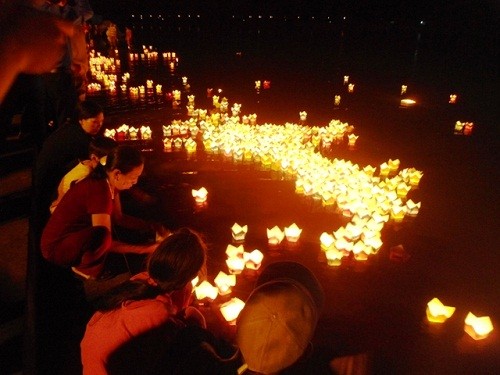 Con sông bừng sáng vì hàng nghìn ngọn nến trên đèn hoa đăng được thả xuống.
