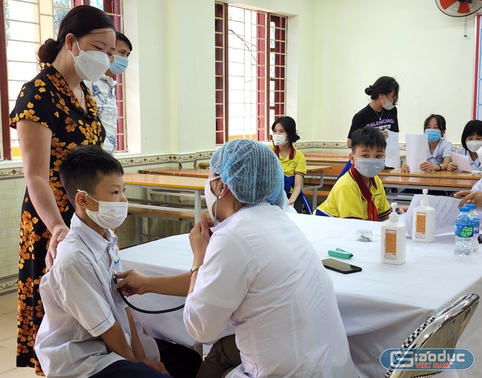 Học sinh được khám sàng lọc, tư vấn các triệu chứng sau khi tiêm vaccine (Ảnh: Phạm Linh)
